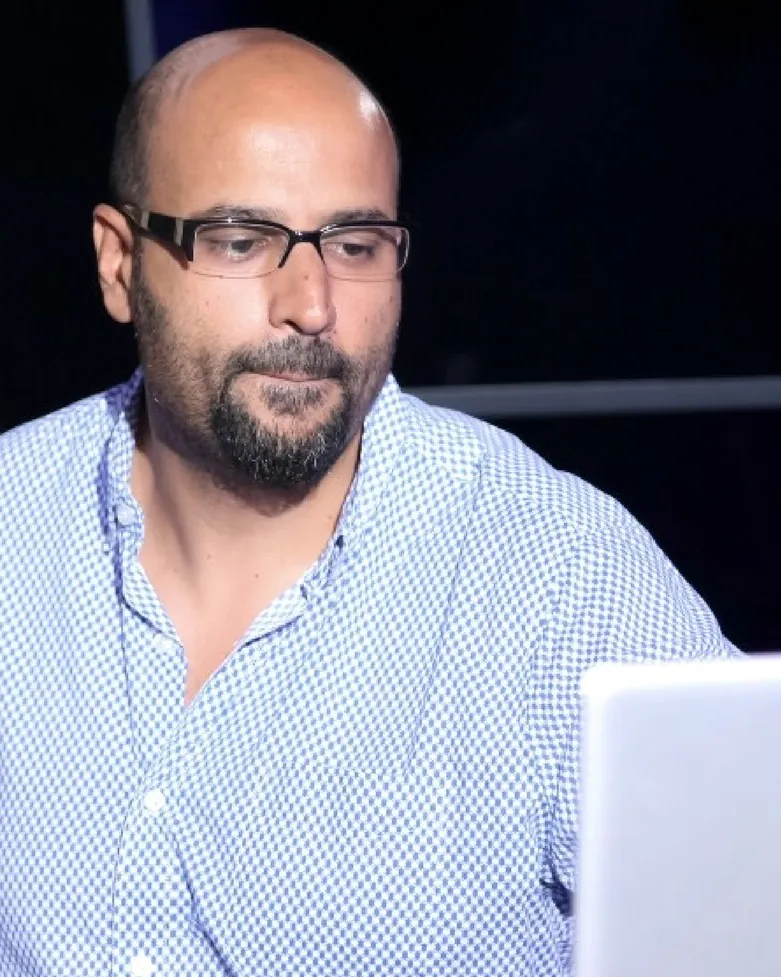Rahim Mapara in a blue shirt, behind the decks